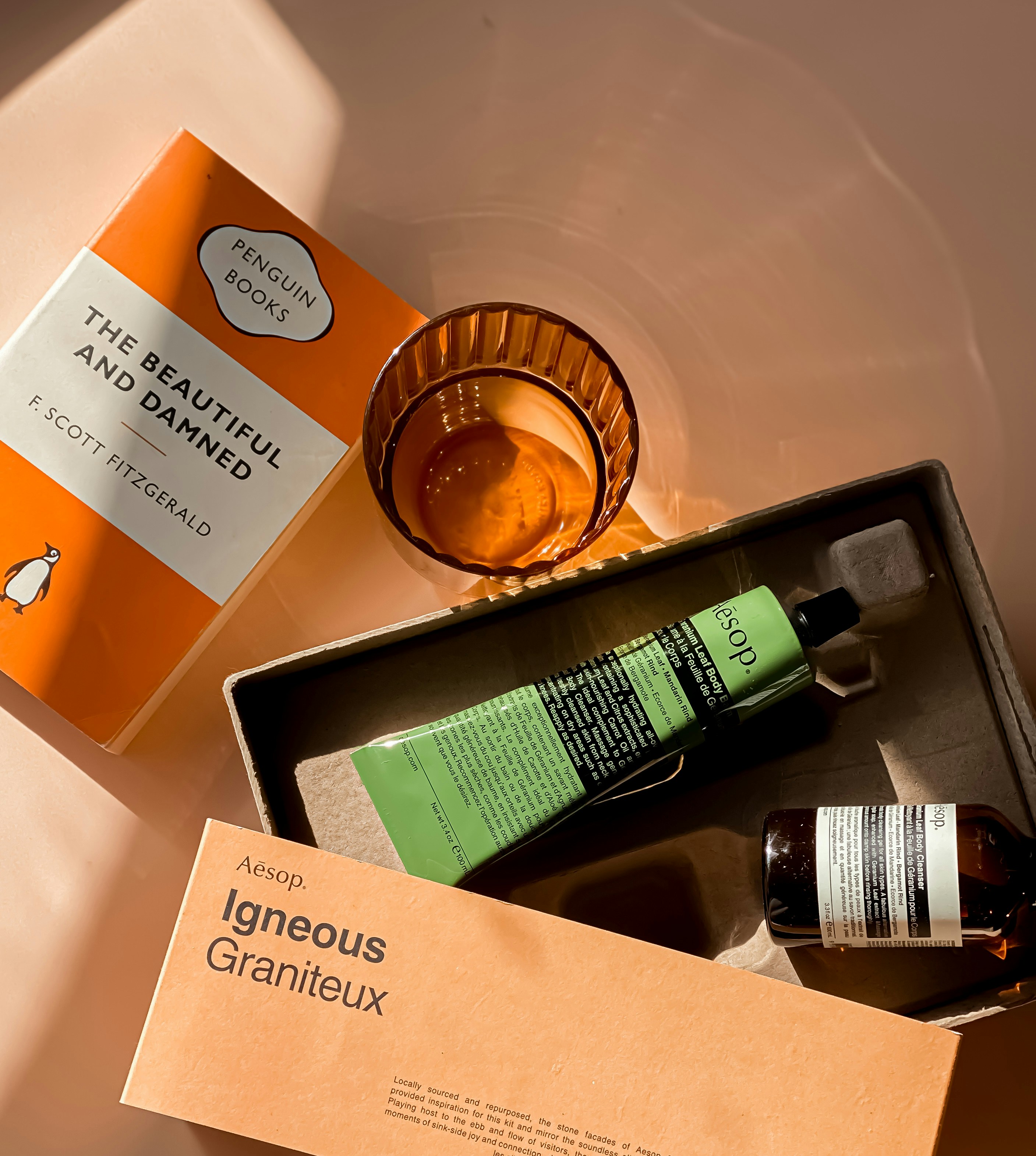 An open box containing a bottle of liquid and a glass, representing packaging design concepts